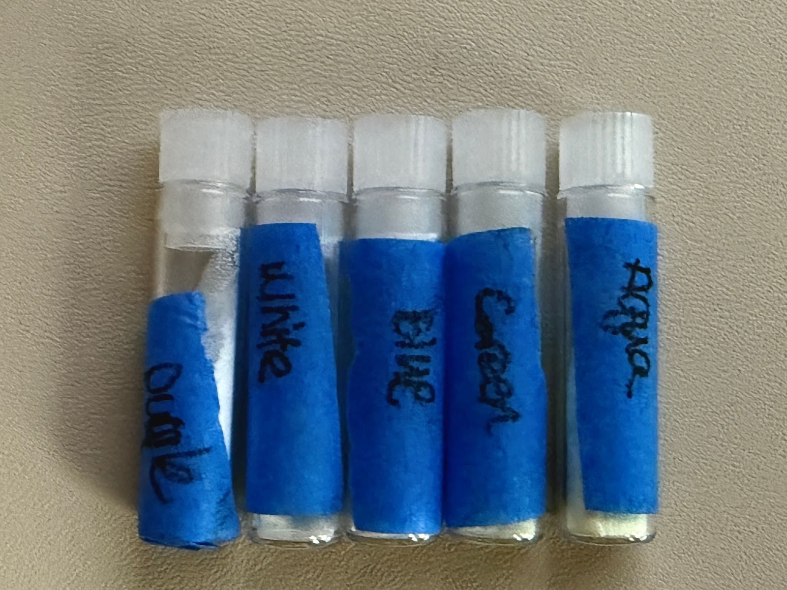 glow powder in transparent vials labeled with blue tape